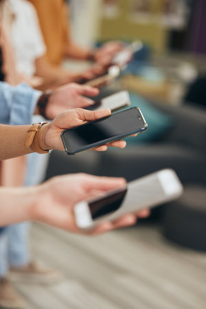Social media, hands and row of smartphone people for internet app communication or wifi streaming. Phone consumer group holding device for digital leisure and online entertainment in a lineの写真素材