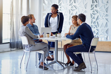 Lets get this meeting started. a group of colleagues working together in an office.の写真素材