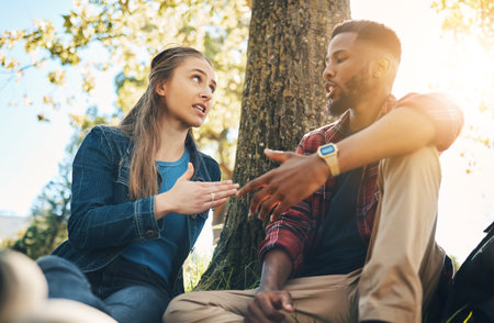 Conversation, argument and interracial couple in conflict in a park for communication about divorce. Angry, fight and black man and woman speaking about a relationship problem on a date in natureの写真素材