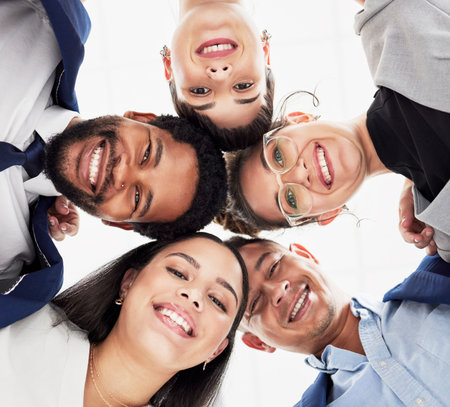 Team building, support or portrait of business people in huddle for collaboration, partnership or community. Faces, low angle or happy group of workers with smile, mission goals or target togetherの写真素材