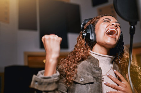 Music, singing and recording studio with a black woman celebrity at her record label to sing a song for her new album. Creative, art and performance with a female singer streaming live on the radioの写真素材