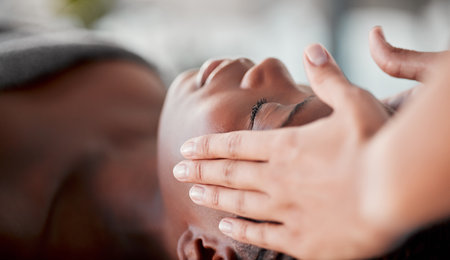 Spa, face massage and black woman luxury for skincare wellness, peace and calm in beauty treatment. Facial therapist and hands for person zen, client healing and stress relief while relax or sleepingの写真素材