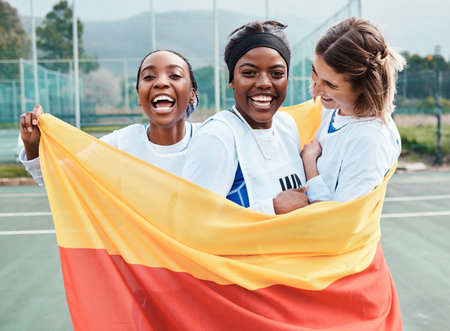 Winning netball, flag and sports team celebration, excited or celebrate competition award, victory winner or court game. Germany people, teamwork achievement and portrait of athlete happy for successの写真素材