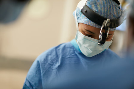 Focused on a very precise procedure. a surgeon performing a surgery in an operating room.の写真素材