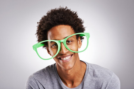 Have some fun making a spectacle of yourself. Studio shot of a young man wearing novelty glasses...
