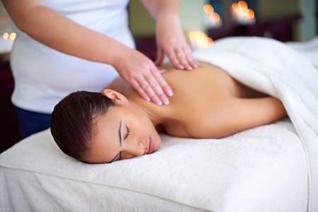 Make time for yourself. a young woman enjoying a back massage at a spa.の写真素材