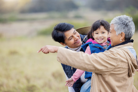 Farm, agriculture and parents with girl in countryside for holiday, vacation and adventure on grass field. Farming, family adoption and happy child with lesbian couple for quality time on ranchの写真素材