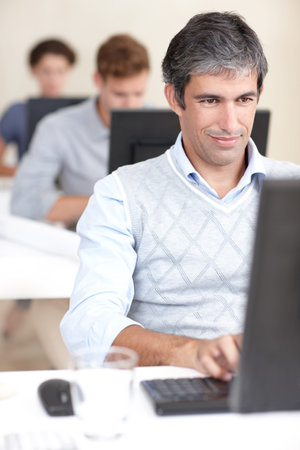 I put one hundred percent into my job. an office worker at work on his computer surrounded by...