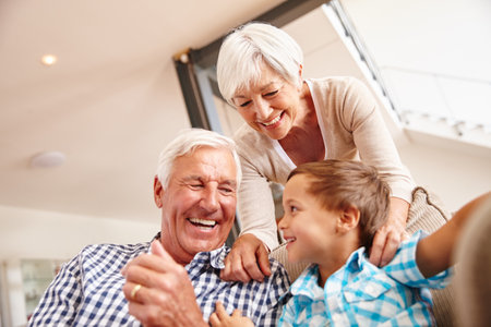 Having a bundle of laughs together. a young boy with his grandparents.の写真素材