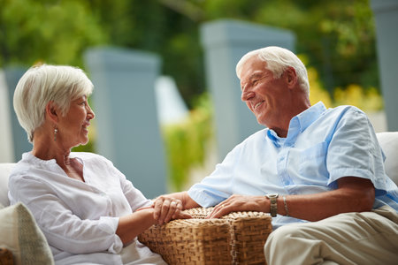 Enjoying a happy retirement together. a senior couple having a conversation on their patio.の写真素材