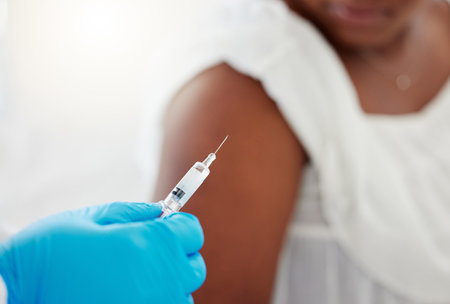 Hand, covid vaccination and a patient with her doctor in the hospital for an injection of medicine or antibiotics. Healthcare, medical and consulting with a healthcare professional holding a syringeの写真素材