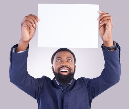 Business, excited man and poster in white background, studio or mockup space. Happy corporate, black male and holding board, marketing wow news and advertising banner for blank mock up, paper or signの写真素材