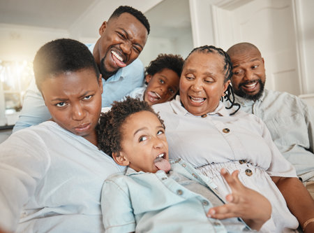 Funny, goofy and selfie of black family make joke with faces in a home or house while on vacation or holiday. Social media, mother and father with children and grandparents happy bonding with humorの写真素材
