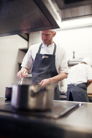 Dinner will be served shortly. chefs preparing a meal service in a professional kitchen.