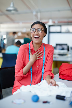 They chose my design. a young female designer looking inspired while working on designs at her desk.の写真素材