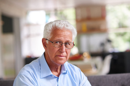 Life is what you make of it. a thoughtful looking senior man sitting on his sofa.の写真素材