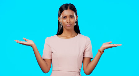 Choice, option or decision and a woman on a blue background in studio with a hand gesture. Portrait, balance and scale with an attractive young female weighing up the pros and cons of a variableの写真素材