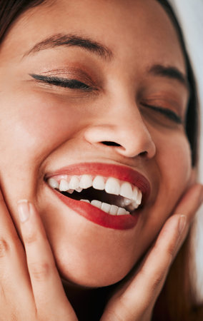 Face closeup, woman laughing and makeup of a gen z, youth and female model with cosmetics. Laugh, carefree and natural beauty of a young person with skin textures and cosmetic care with self loveの写真素材