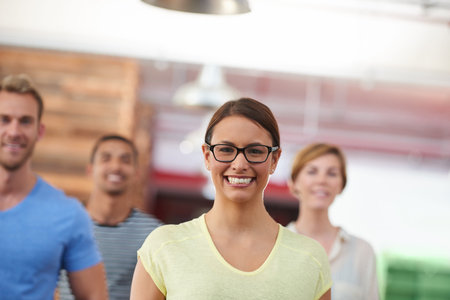 Her drive inspires her team to succeed. Portrait of a team of confident colleagues in a casual working environment.の写真素材