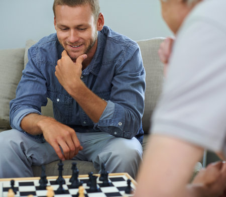 Well played, Dad. a father and son playing a game of chess together at home.の写真素材