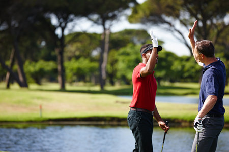 Up top. two golfers congratulating each other with a high five.の写真素材