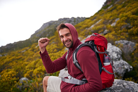 Im halfway there. a young man enjoying a hike through the mountains.の写真素材