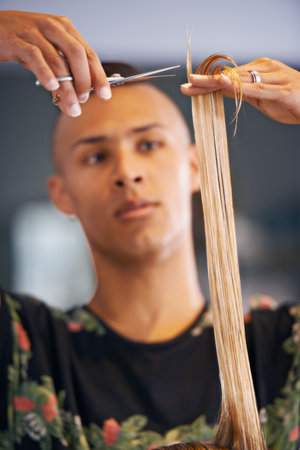 He knows how to make his clients happy. a male hairdresser cutting a clients hair.の写真素材
