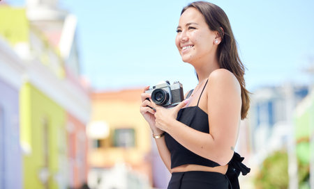 Photography, summer and happy photographer with camera shooting pictures of colorful houses in the city. Smile, woman and creative freelancer takes a photo of Cape Town on a holiday vacation outdoorsの写真素材