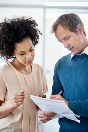Supportive colleagues bring success. two colleagues discussing ideas on a notepad.の写真素材