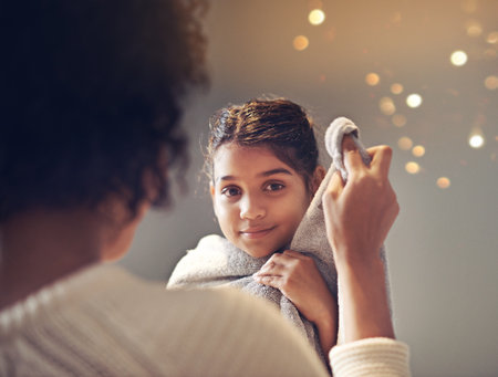 Squeaky clean after her bath. a mother drying off her daughter with a towel in the bathroom.の写真素材