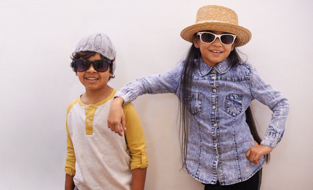 Stay cool. Portrait of a brother and sister wearing sunglasses and hats.の写真素材