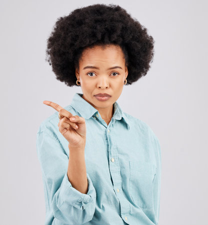 Finger, serious and portrait of black woman in studio with hand gesture for disagreement, upset and anger. Mockup space, white background and isolated girl point for angry, no and disappointment signの写真素材