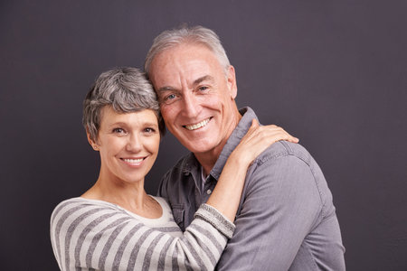Hes my one and only. Studio portrait of an affectionate elderly couple against a gray background.の写真素材