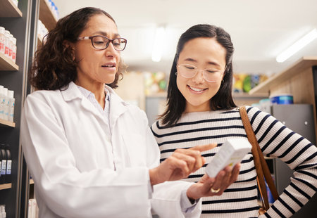 Happy woman, medicine shopping or pharmacist in reading retail healthcare supplements information. Pharmacy or doctor helping Asian customer with store medication advice, pills box or medical drugsの写真素材