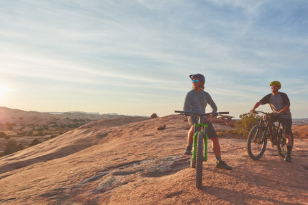 The best days end off with a bike ride. Full length shot of two young male athletes mountain biking in the wilderness.の写真素材