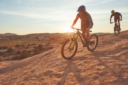 Cycling is an instant vacation. Full length shot of two young male athletes mountain biking in the wilderness.の写真素材