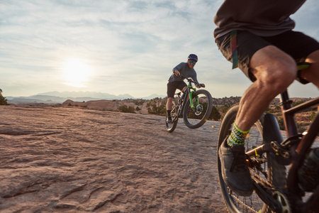 Nature provides a plethora of options to test your skills and endurance. two men out mountain biking together during the day.の写真素材