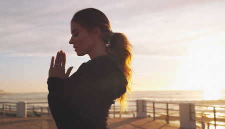Thank goodness for yoga. a woman practising yoga on the promenade.の写真素材