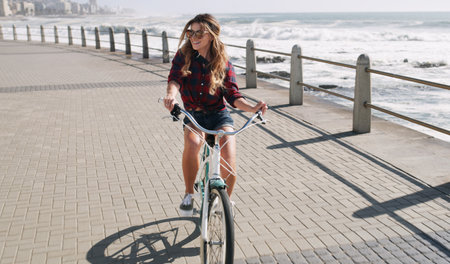 Make time for the things that set your soul on fire. a beautiful woman out on the promenade with her bicycle.の写真素材