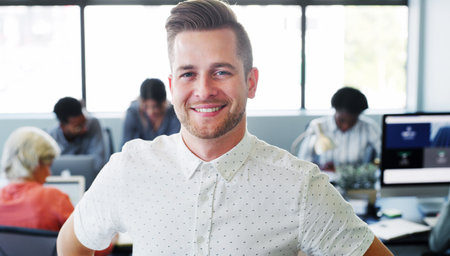 Be your best and youll be the best. Portrait of a confident young businessman working in a modern office with his colleagues in the background.の写真素材