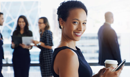 I wasnt born to blend in. an attractive businesswoman smiling at the camera while colleagues are blurred in background.の写真素材