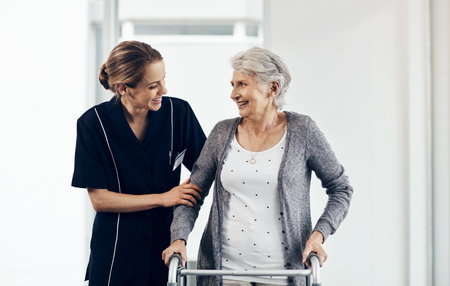 I couldnt have done it without your motivation. a female nurse assisting a senior woman using a walker.の写真素材