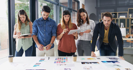 Putting new plans into action. a group of designers brainstorming together in an office.の写真素材