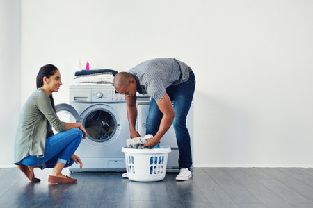 Theres something attractive about men doing chores. a young woman doing laundry at home.の写真素材