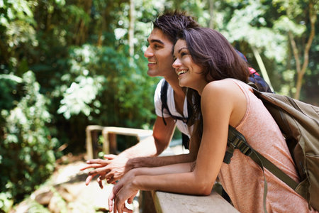 Enjoying their forest escape. a young couple enjoying the scenery while out hiking through the forest.の写真素材