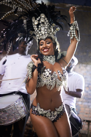 Glamourous dancing queen. a beautiful samba dancer performing in a carnival with her band.の写真素材