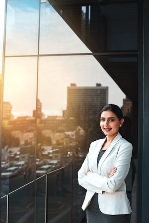 My ambitions are as big as the city. Portrait of a young businesswoman standing on the office balcony.の写真素材