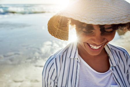 Living on the bright side of life. a young woman enjoying a day at the beach.の写真素材