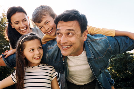 The best weekends are spent with family. a happy family of four having fun outdoors.の写真素材