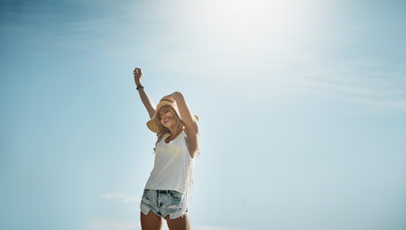 The sun has a way of inspiring spontaneity. Portrait of an attractive young woman enjoying a summers day outdoors.の写真素材